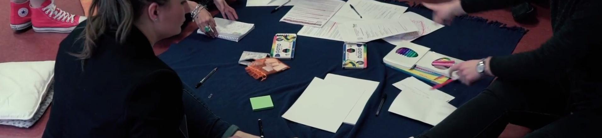 Studenti seduti a terra attorno a libri e appunti